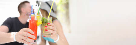 Man and woman holding alcoholic cocktails and kissingの写真素材