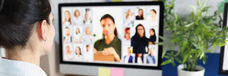 Woman communicating with group of business people via video conferencingの写真素材