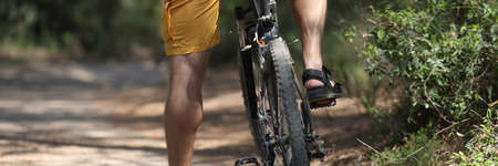 Man in shorts sitting on bicycle in park closeupの写真素材