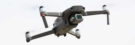 Silvery drone flies in sky. Drone aerial photography