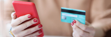 In female hands plastic credit card and smartphoneの写真素材