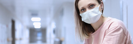 Portrait of woman in protective medical mask in corridor of t hospitalの写真素材