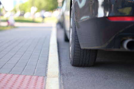 Car is parked near yellow median strip closeup