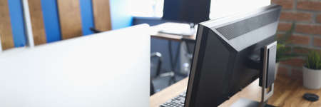 Many computers standing on table in empty classroom