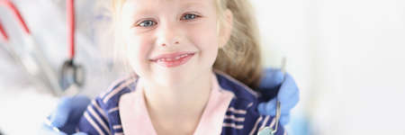 Little smiling girl sitting at dentist appointment
