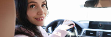 Portrait of smiling woman driver in car salon