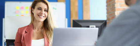 Smiling businesswoman communicates with her male colleague at work