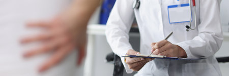 Patient complains to doctor about back painの写真素材