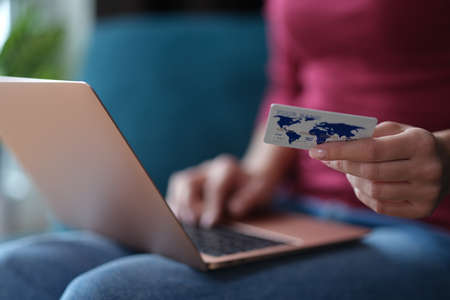 Woman is shopping online using laptop closeupの写真素材