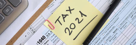 Tax form for 2021 with pen and report is on table
