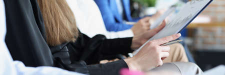 Lot of people with documents in their hands are sitting in business training closeupの写真素材