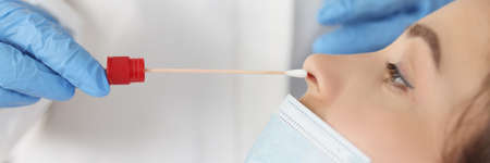 Doctor in protective medical gloves taking nasal swab of pcr with cotton swab