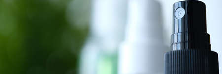 Cosmetic bottle with dark colored cosmetic product with spray bottleの写真素材