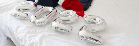 Numbers 2022 and collected suitcase with things with santa claus hats lie on bedの写真素材