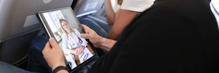 Man receives medical advice on video call while sitting on airplane