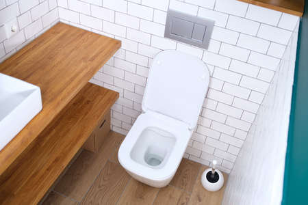White toilet bowl with open lid standing in bathroom backgroundの写真素材