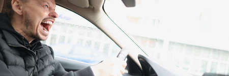 Angry screaming male driver driving car closeupの写真素材