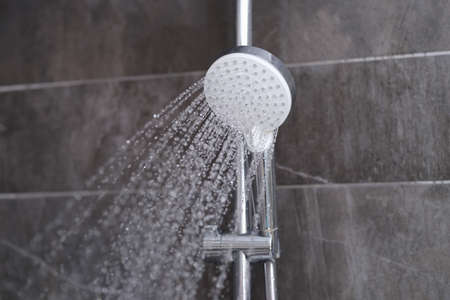 Cheap tap is pouring rain in the bathroom closeupの写真素材