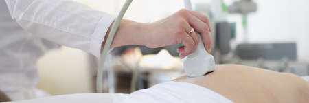 Ultrasound scanner device in hand of professional doctor examining his patientの写真素材