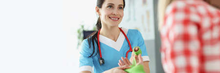 Woman traumatologist bandaging injured arm of young female patient in clinicの写真素材