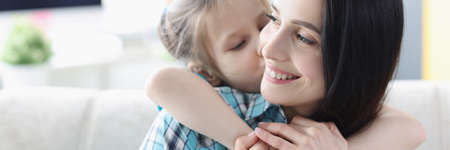 Little girl hugging young woman at homeの写真素材