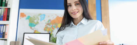 Portrait of business lady sitting at her desk and studying financial documents