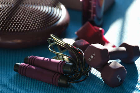 Sports accessories dumbbell skipping rope lie on mat closeupの写真素材