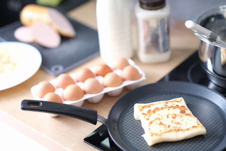 Pancake with delicious filling frieding in pan in kitchen closeupの写真素材