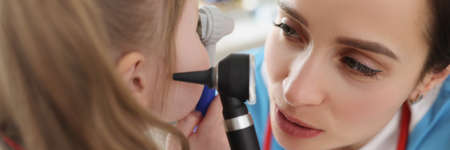 Otolaryngologist examines ear of little girl patientの写真素材
