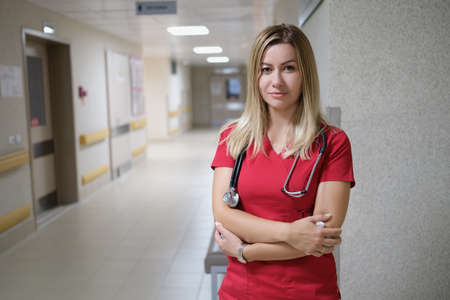 Portrait of young beautiful female doctor in red uniform and stethoscopeの写真素材