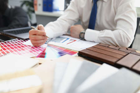 A male designer chooses a color from a palette