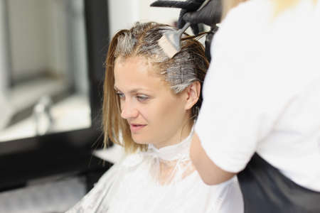 Woman dyes her hair in the salonの写真素材