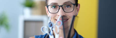 Portrait of woman hairdresser holding scissors and comb in hand. Hairdresserの写真素材