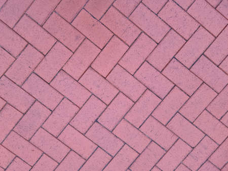 Paving slabs laid out in shape of herringbone on city street background