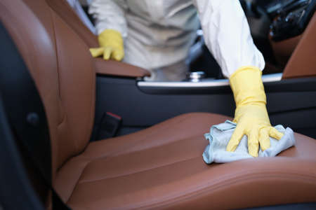 Man polishing luxury leather interior of carの写真素材