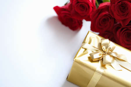 Beautifully wrapped gift in gold paper with ribbonの写真素材