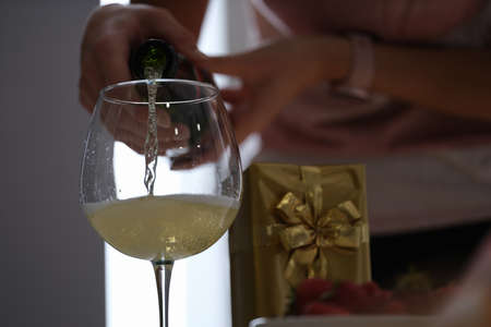 Woman pouring champagne into a glass, celebration