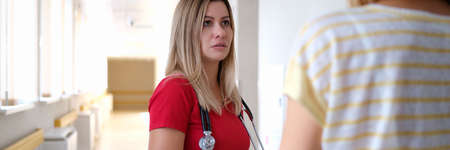 Female doctor communicates with patient in hospital corridor