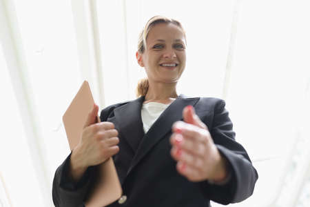 Young woman in business suit stretching out her hand for handshake bottom viewの写真素材