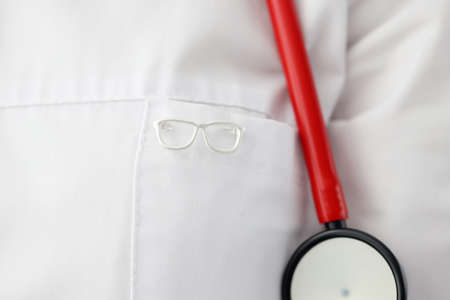 Eyeglass shape icon hanging on ophthalmologist gown closeupの写真素材