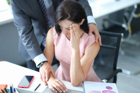 Businessman pestering female colleague in the workplace.の写真素材