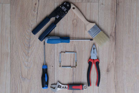 House figure assembled from construction tools on wooden backgroundの写真素材