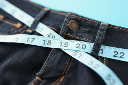 Denim trousers or jeans with blue measure tape around waistの写真素材