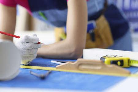 Woman worker making corrections in construction planning with pencilの写真素材