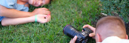 Man photographing young woman sleeping on grassの写真素材