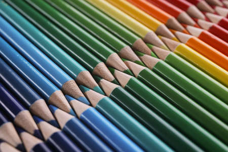 Colourful childrens drawing pencils pointing one another in lineの写真素材