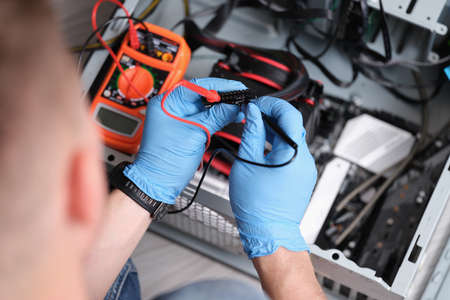 Man working with multimeter for computer repairの写真素材