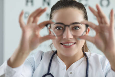 Woman eye doctor with eye test chart on backgroundの写真素材