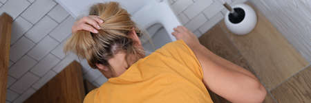Woman bowing her head over toilet in bathroom top viewの写真素材