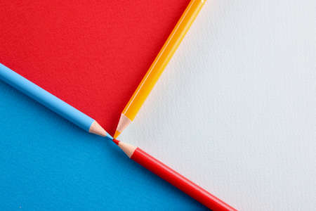 Multicolored pencils lying on paper background closeupの写真素材